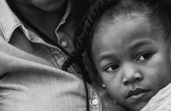 Child resting her head on her mother's chest