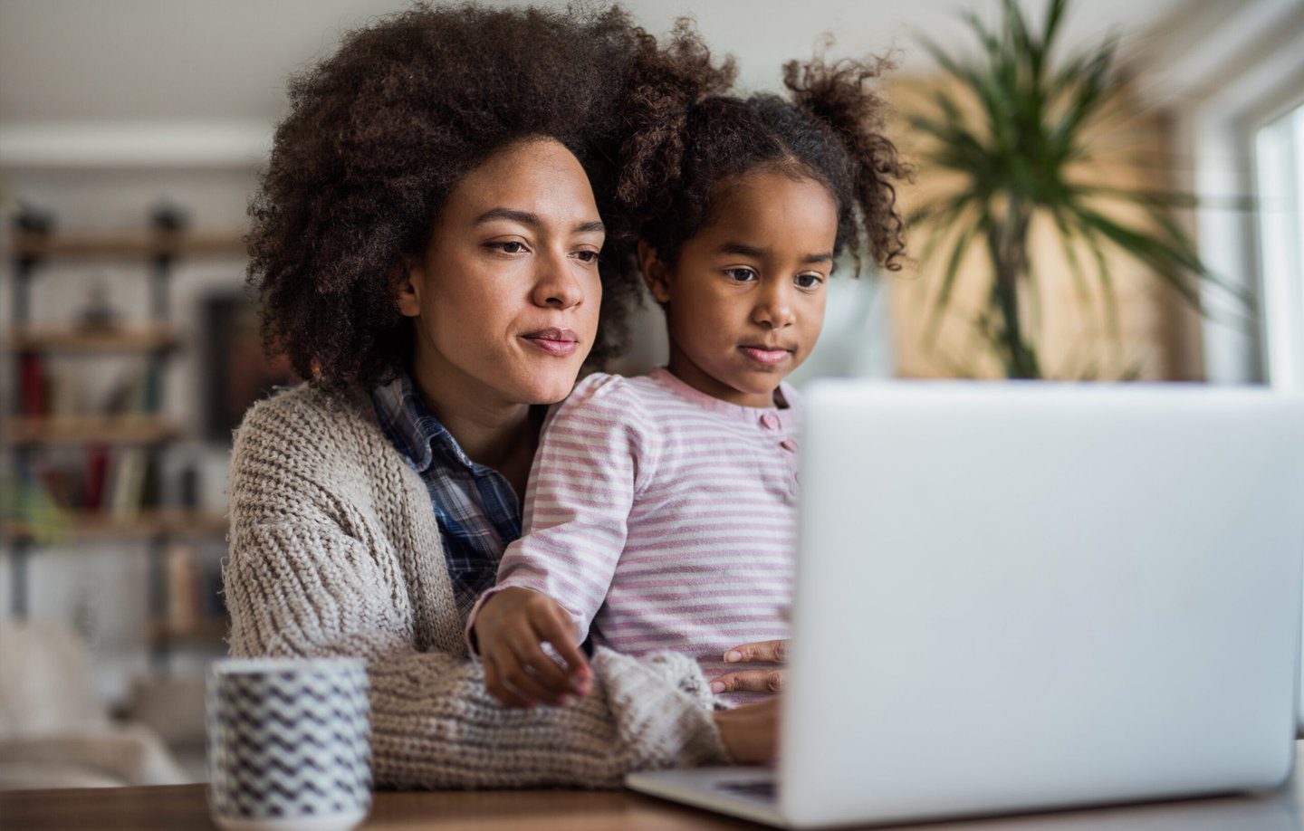 Child with her mother looking at a laptop