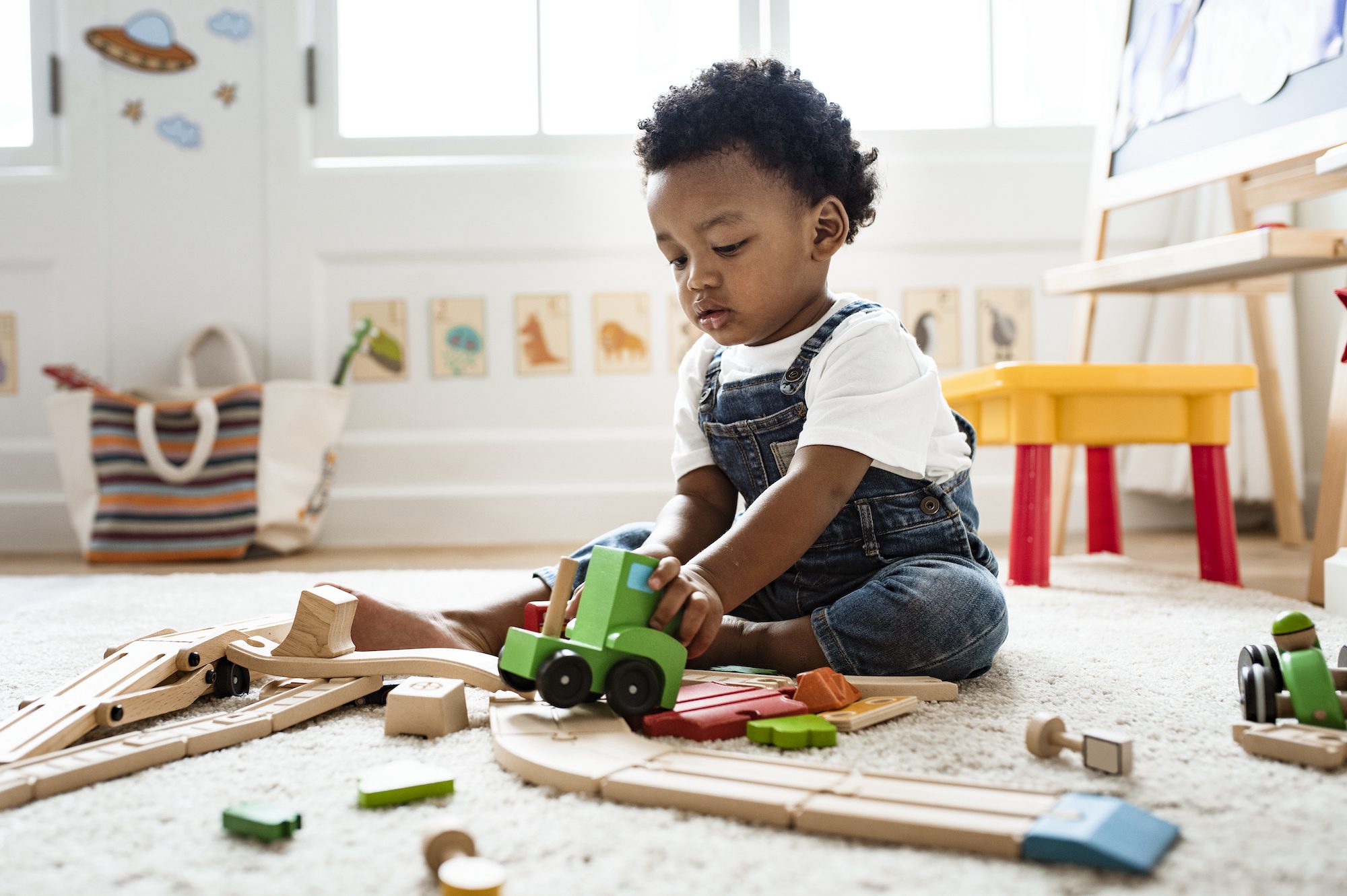 Cute little boy playing with a railroad train toy