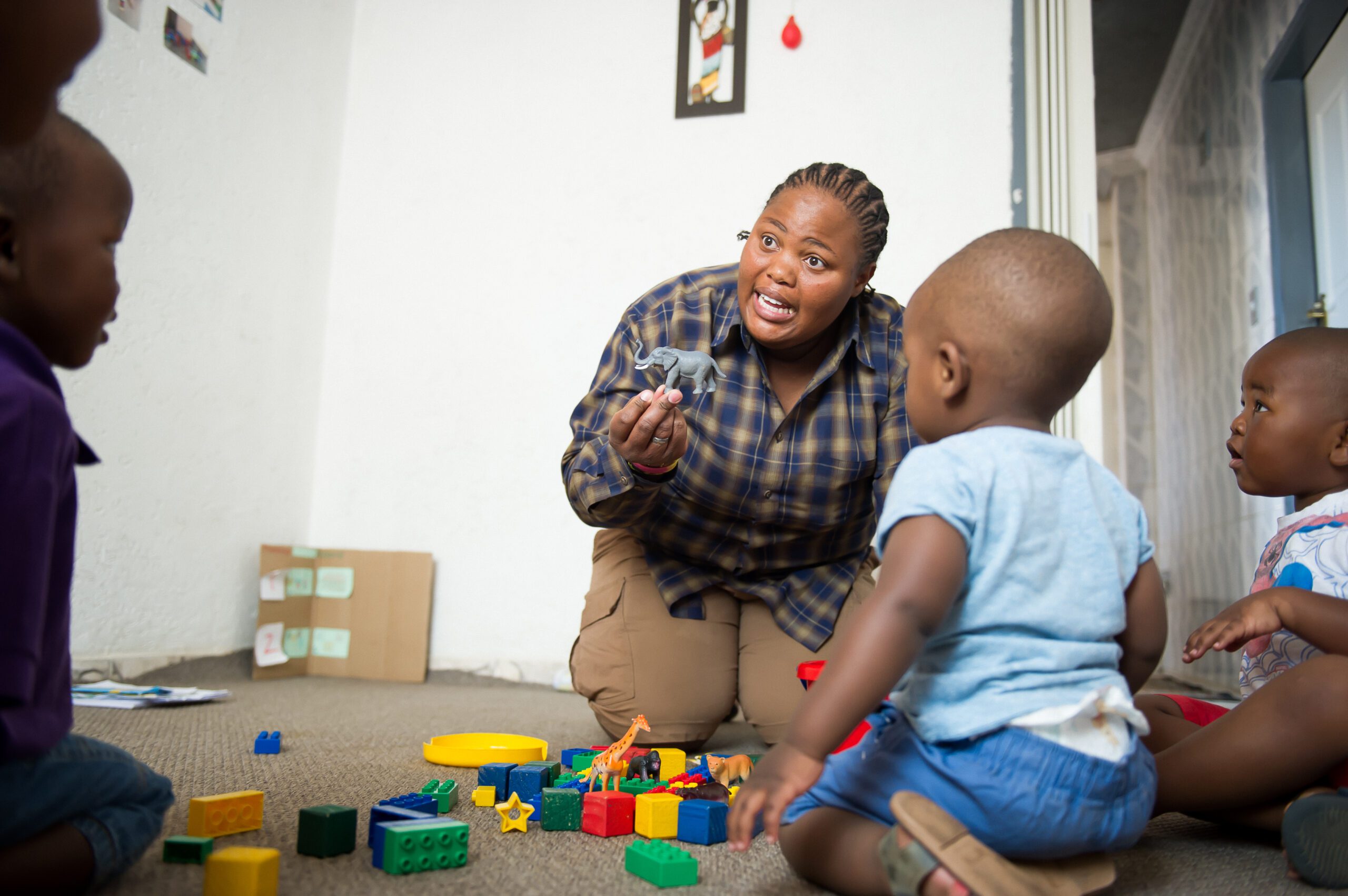 Woman on the ground playing with children