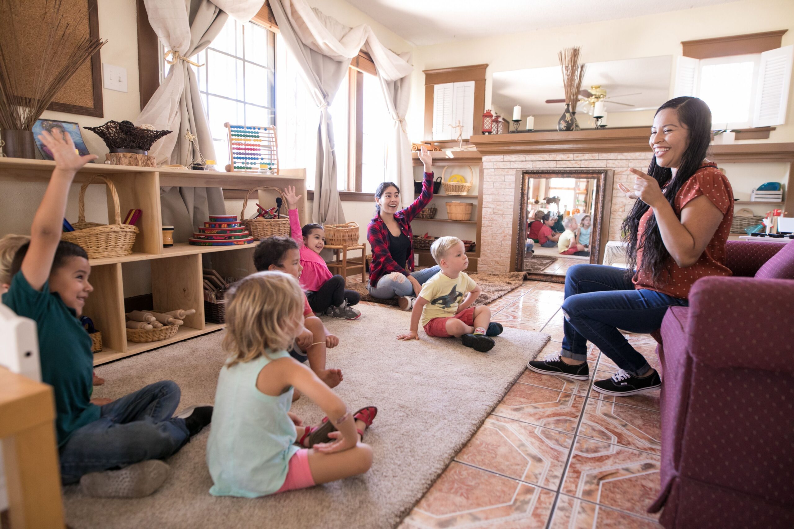 Woman interacting with a group of children sitting on the floor