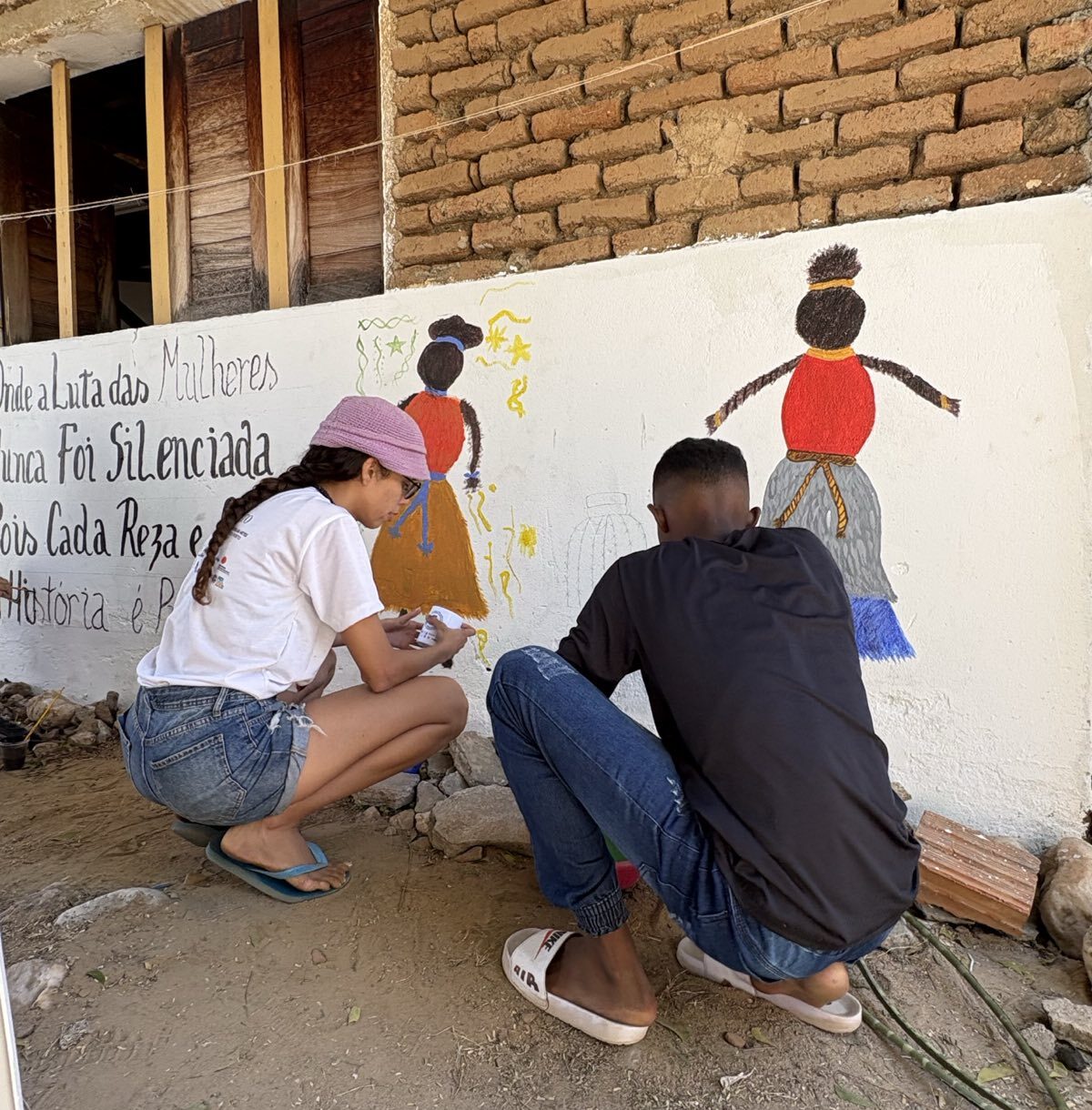 Two people painting a wall