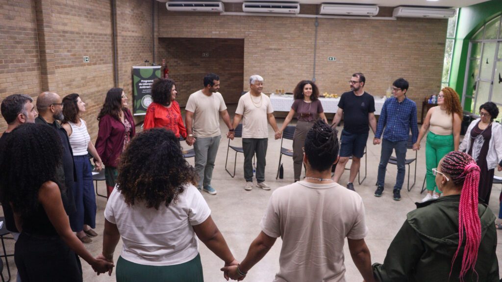 Group of people standing in a circle, holding hands