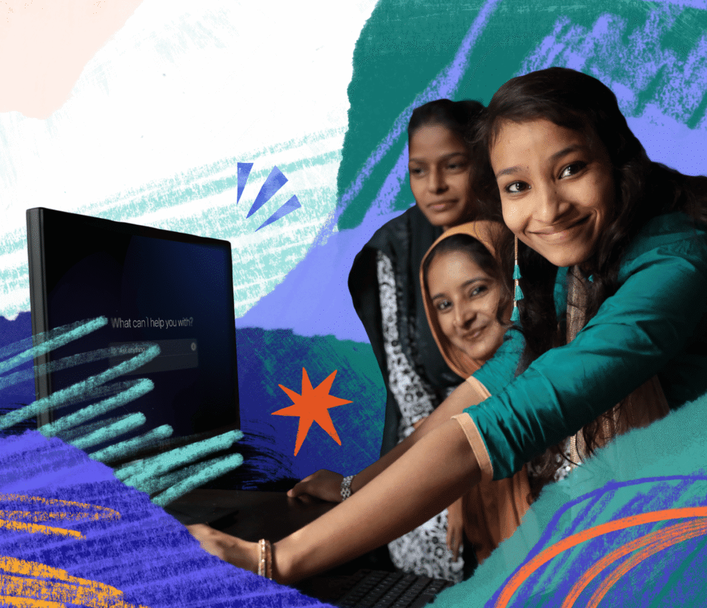 three women leaning over a computer smiling